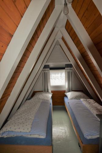 two beds in a attic with a window at Ferienhaus Giebelei in Medebach