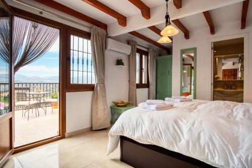 a bedroom with a large bed and a balcony at Casa las Torres B&B in Iznate