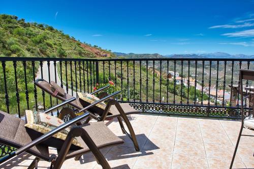 a balcony with two chairs and a view of the ocean at Casa las Torres B&B in Iznate