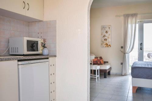 a kitchen with a microwave on top of a counter at Panorama Fanari studios and apartments in Argostoli