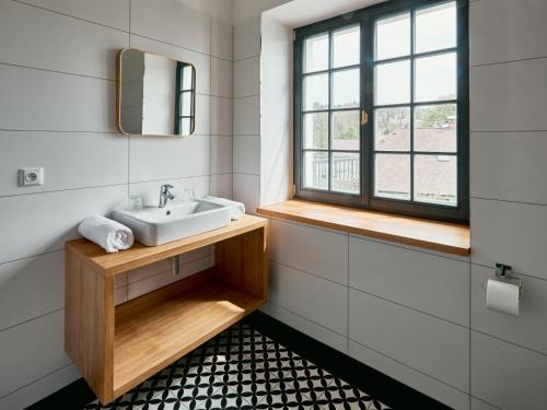 a bathroom with a sink and a window at Hotel a Hostinec Slunce in Osečná