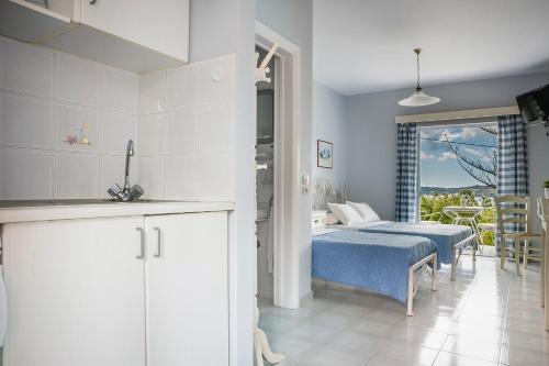 a kitchen and a bedroom with a bed and a window at Panorama Fanari studios and apartments in Argostoli