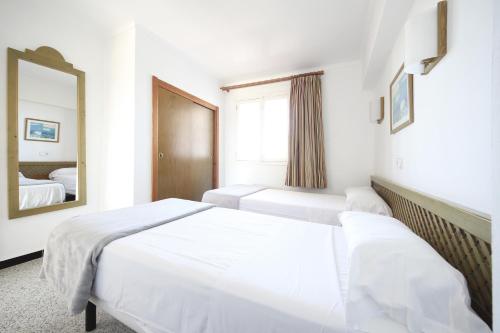 Pokój hotelowy z 2 łóżkami i lustrem w obiekcie Aparthotel Niu d´Aus w mieście Portopetro