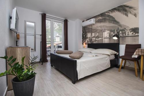 a bedroom with a bed and a table and a chair at Apartmani i studio Big Hill in Makarska