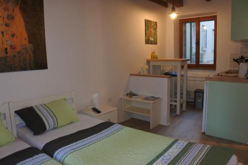 a small bedroom with two beds and a kitchen at Apartments Jago in Piran