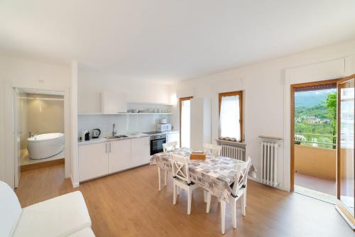 a kitchen and dining room with a table and chairs at Dolomiti Suite in Belluno
