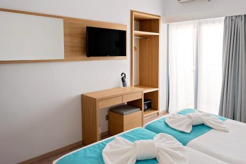 a bedroom with a bed and a television at Pyramos Hotel in Paphos