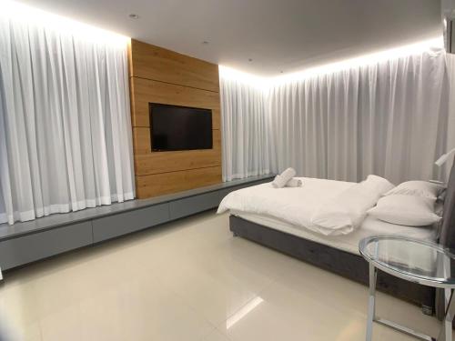 a bedroom with a bed and a flat screen tv at villalis in Eilat