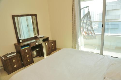 a bedroom with a bed and a mirror and a window at Marina BestView coral in Dubai