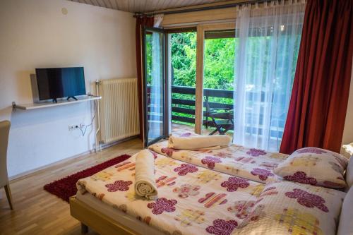 a bedroom with a bed and a large window at Apartments and Rooms Villa Vive in Bled