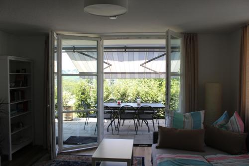 uma sala de estar com uma porta de vidro que leva a um pátio em Dreiländerblick em Lörrach