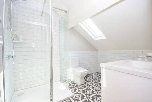 a bathroom with a shower and a toilet and a sink at Queens Quarter Townhouse 2 in Belfast