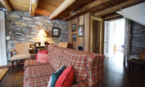 a living room with a couch and a stone wall at Graves Mountain Farm & Lodges in Syria