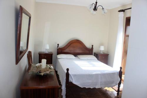 Praia da Torreira à Vista في توريرا: غرفة نوم بسرير وطاولة مع مرآة