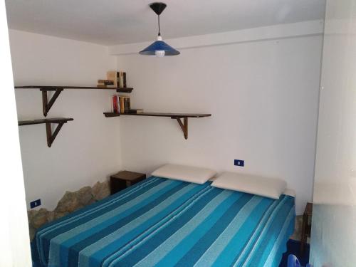 um quarto com uma cama com riscas azuis em Appartamenti Jeko em Lampedusa