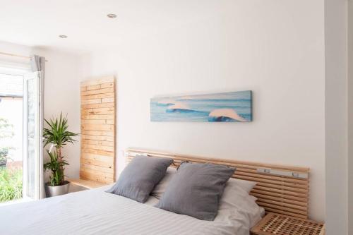 1 dormitorio con 1 cama y una pintura en la pared en Thistledene en Braunton