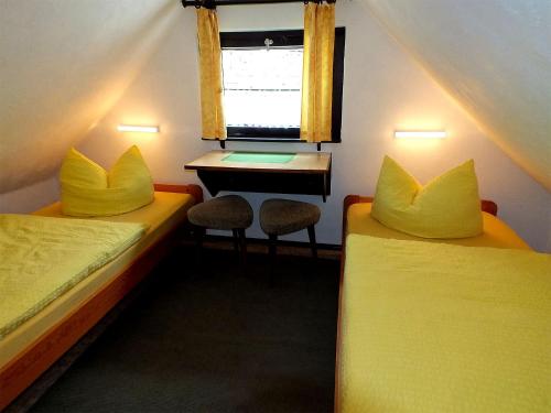 Zimmer mit 2 Betten, einem Schreibtisch und einem Fenster in der Unterkunft Ferienwohnungen Schrot in Bad Schandau