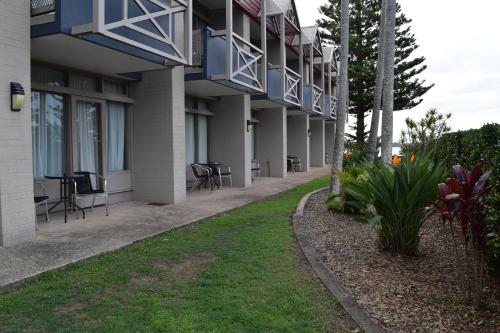 a side view of a building with chairs and tables at Comfort Resort Waters Edge in Port Macquarie