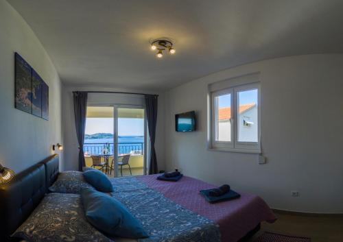 a bedroom with a bed and a window with a view of the ocean at A lovely and cozy room with a breathtaking view in Vis