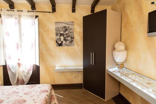 トラーパニにあるCase Vacanze Benvenuti al Sudのベッドルーム1室(黒いキャビネット、窓付)