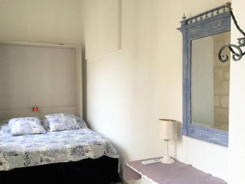 - une chambre avec un lit, un miroir et une lampe dans l'établissement Clos des Arts Suspendus, à Avignon