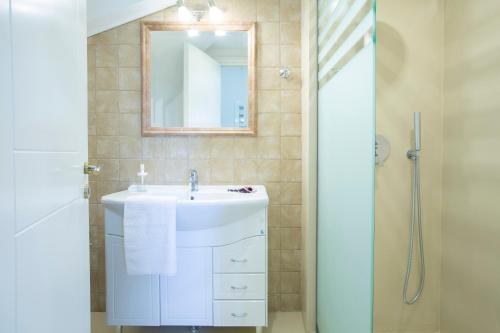 W łazience znajduje się umywalka i lustro. w obiekcie Casa Del Sol w mieście Leukada (miasto)