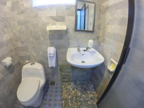 a bathroom with a toilet and a sink at Mamo Hotel Uluwatu in Uluwatu