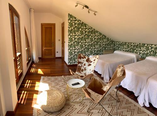 a room with two beds and a chair and a frisbee at Posada La Roblera in Oreña