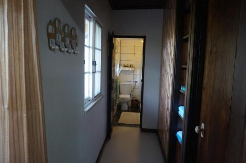 a hallway of a bathroom with a toilet and a window at Portugal House in Praia do Norte