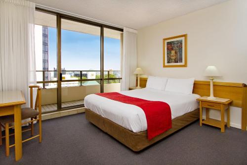 a hotel room with a bed and a large window at Summit Apartments in Brisbane