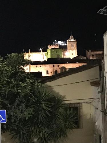 un edificio con una torre de reloj por la noche en Centro Castillo 9, en Cáceres