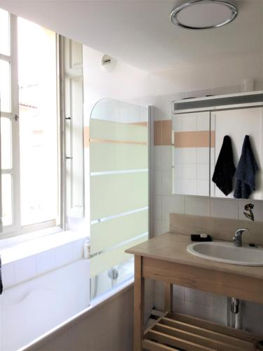 une salle de bain avec un lavabo, une baignoire et un miroir dans l'établissement Clos des Arts Suspendus, à Avignon