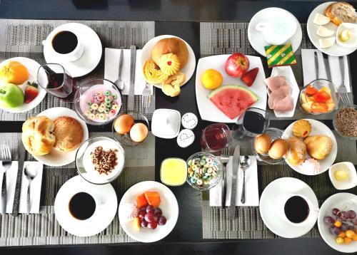 a table with plates of breakfast foods and drinks at Hotel Bellavista Quito in Quito