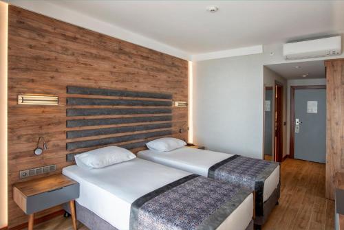 a bedroom with a bed and a wooden wall at Riviera Zen Hotel Adult Only in Alanya