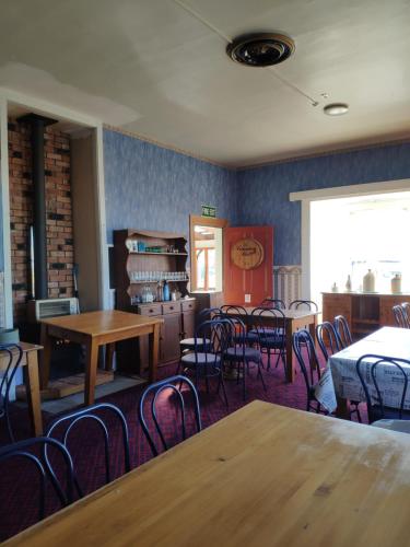 a dining room with tables and chairs and a window at South Rakaia Hotel in South Rakaia