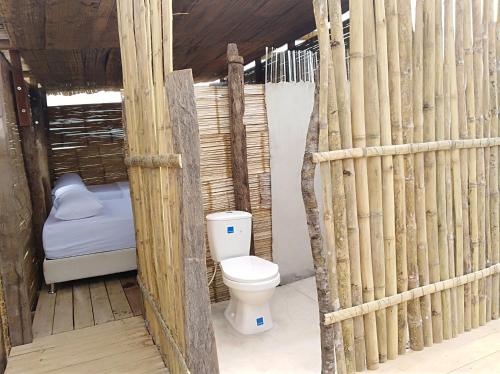 a bathroom with a toilet in a bamboo house at Hotel Flor de Liz Bereshit Bara in Villavieja