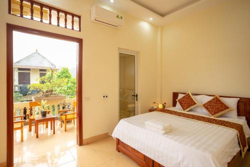a bedroom with a bed and a view of a balcony at Mai Place Homestay in Ninh Binh