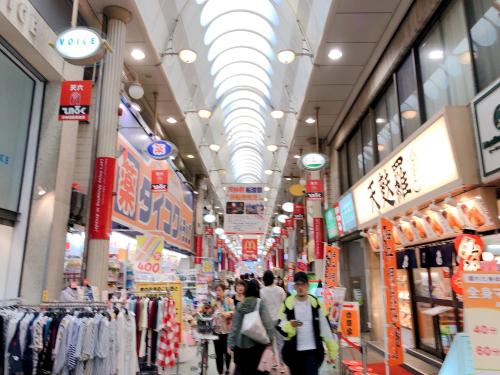 a group of people walking through a shopping mall at Ryokoheya Tenchokan in Osaka