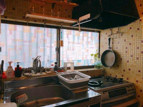 a kitchen with a sink and a counter top at Ryokoheya Tenchokan in Osaka