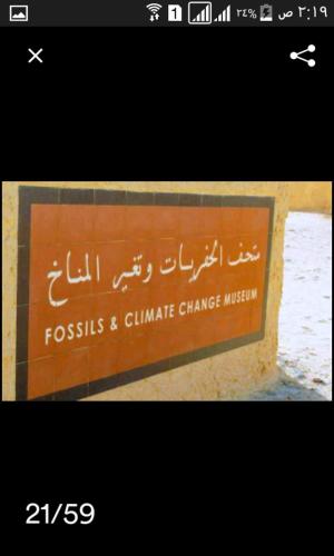 a sign on a wall with some writing on it at villa tunis village in ‘Izbat an Nāmūs