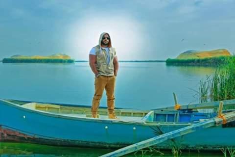 a man standing on a boat in the water at villa tunis village in ‘Izbat an Nāmūs