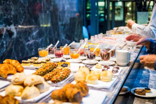 a long table filled with plates of food and drinks at Mercure Living Putrajaya in Putrajaya