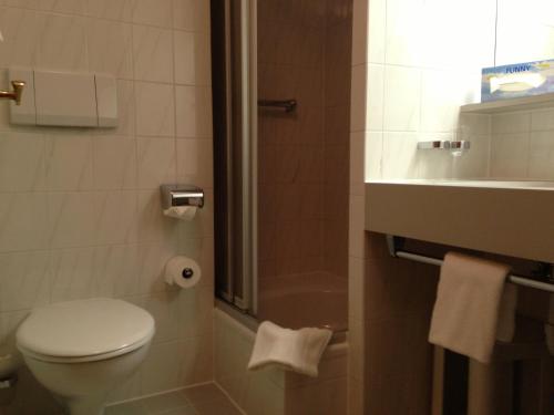 uma casa de banho com um WC, um chuveiro e um lavatório. em Hotel Bergheimat em Schönau am Königssee