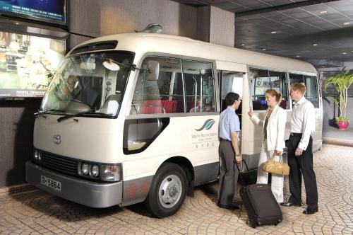 a group of people standing outside of a bus at South Pacific Hotel in Hong Kong