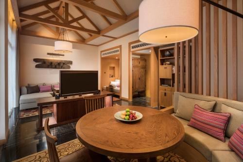 a living room with a table and a couch at Jinmao Pureal Mountain Liiang in Lijiang