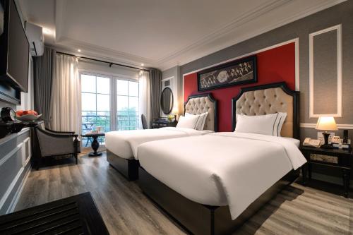 a hotel room with two beds and a window at Acoustic Hotel & Spa in Hanoi