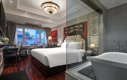 a hotel room with a bed and a desk and a bathroom at Acoustic Hotel & Spa in Hanoi