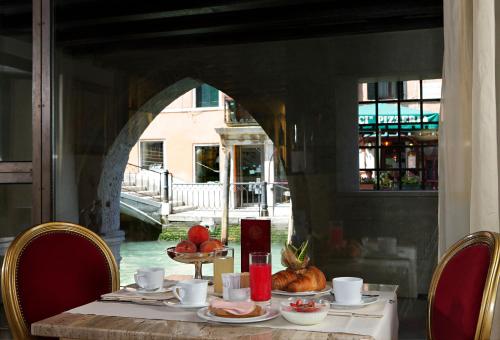 a table with food on it in a restaurant at Hotel Liassidi Palace in Venice