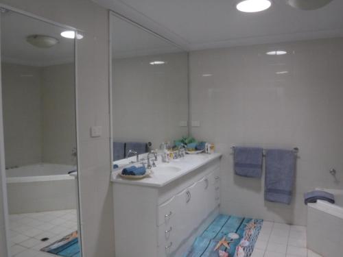 a white bathroom with a sink and a mirror at Meekatharra Outback Beach House in Meekatharra