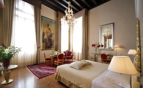 Hotel Liassidi Palace في البندقية: غرفة نوم بسرير وطاولة وكراسي
